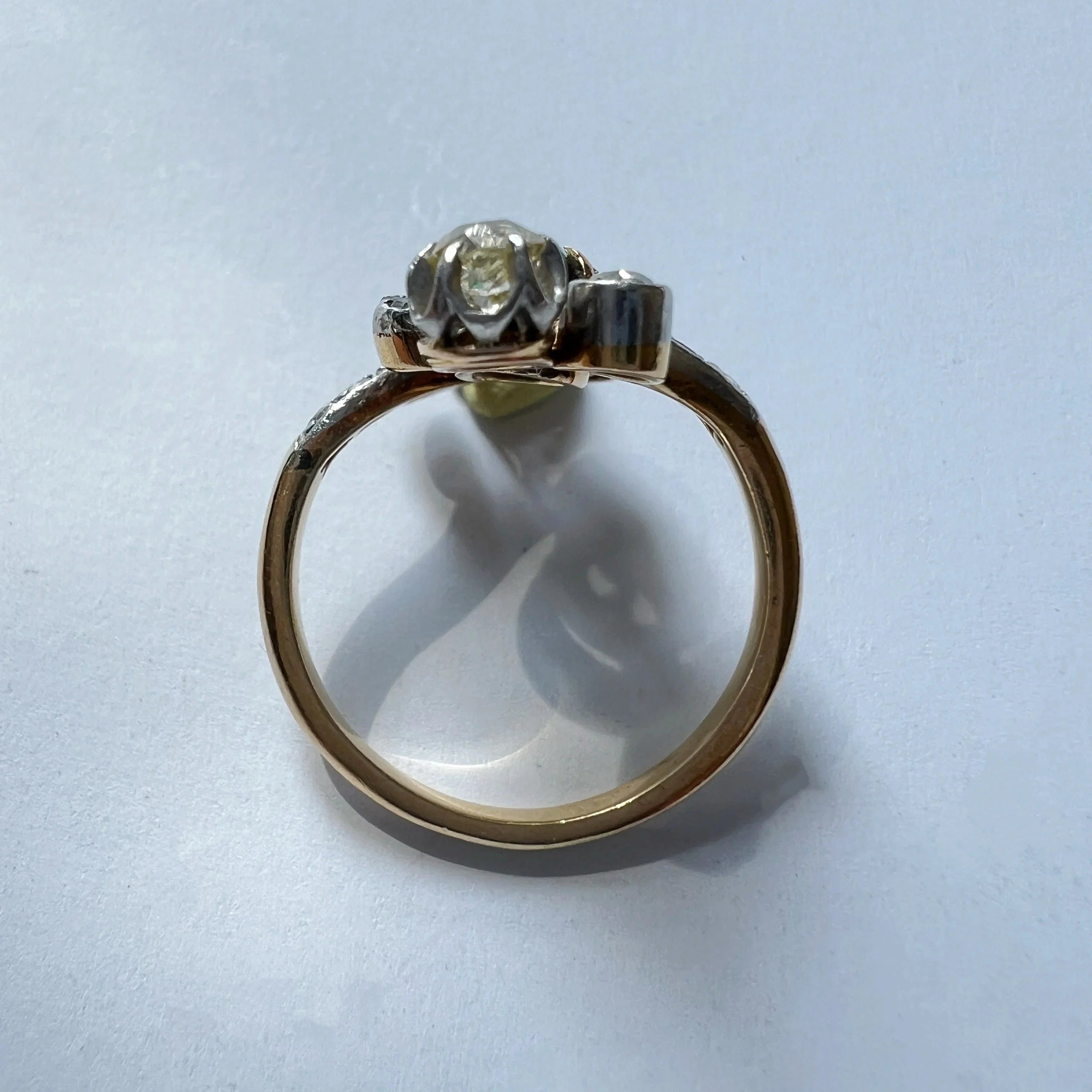 Gold ring with a diamond on a light blue background