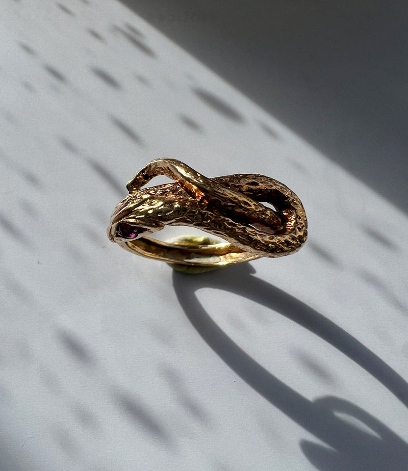 Chiseled 18k yellow plain gold twisted snake ring with ruby eyes