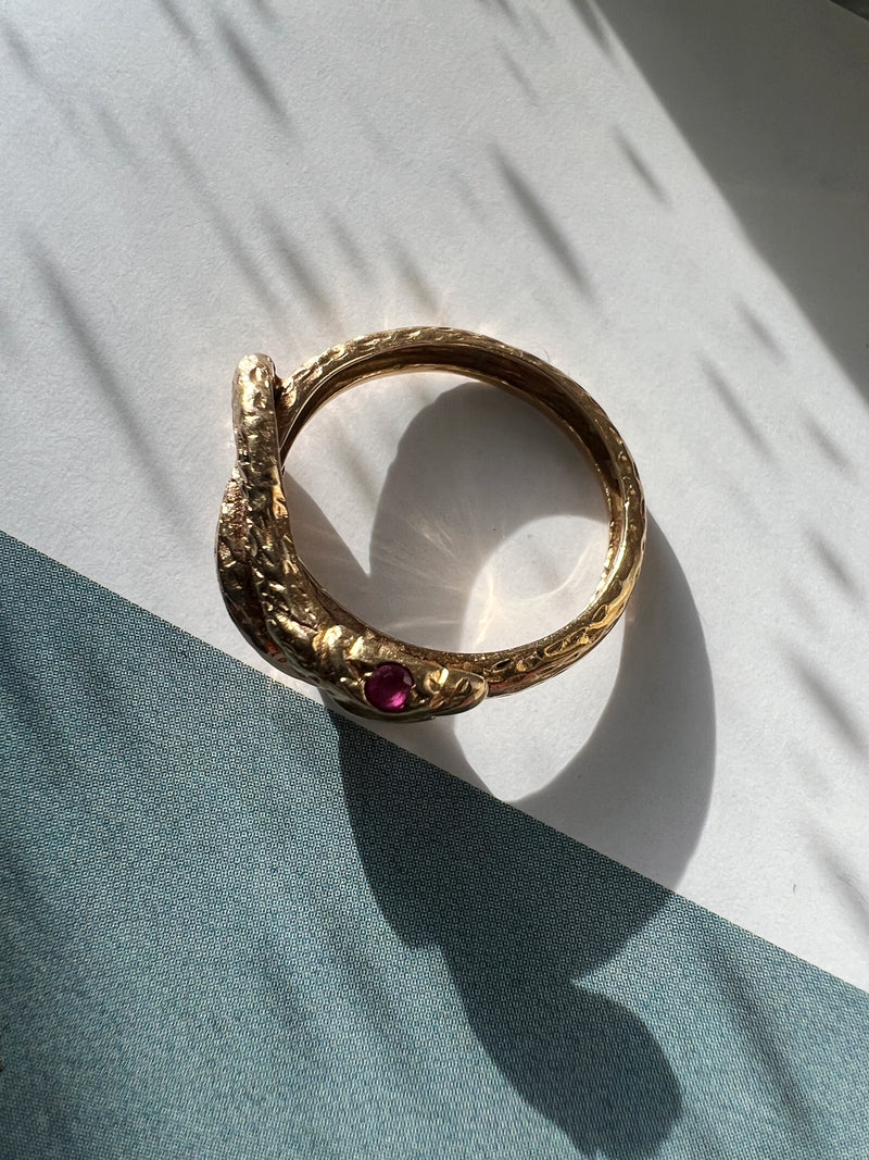 Chiseled 18k yellow plain gold twisted snake ring with ruby eyes